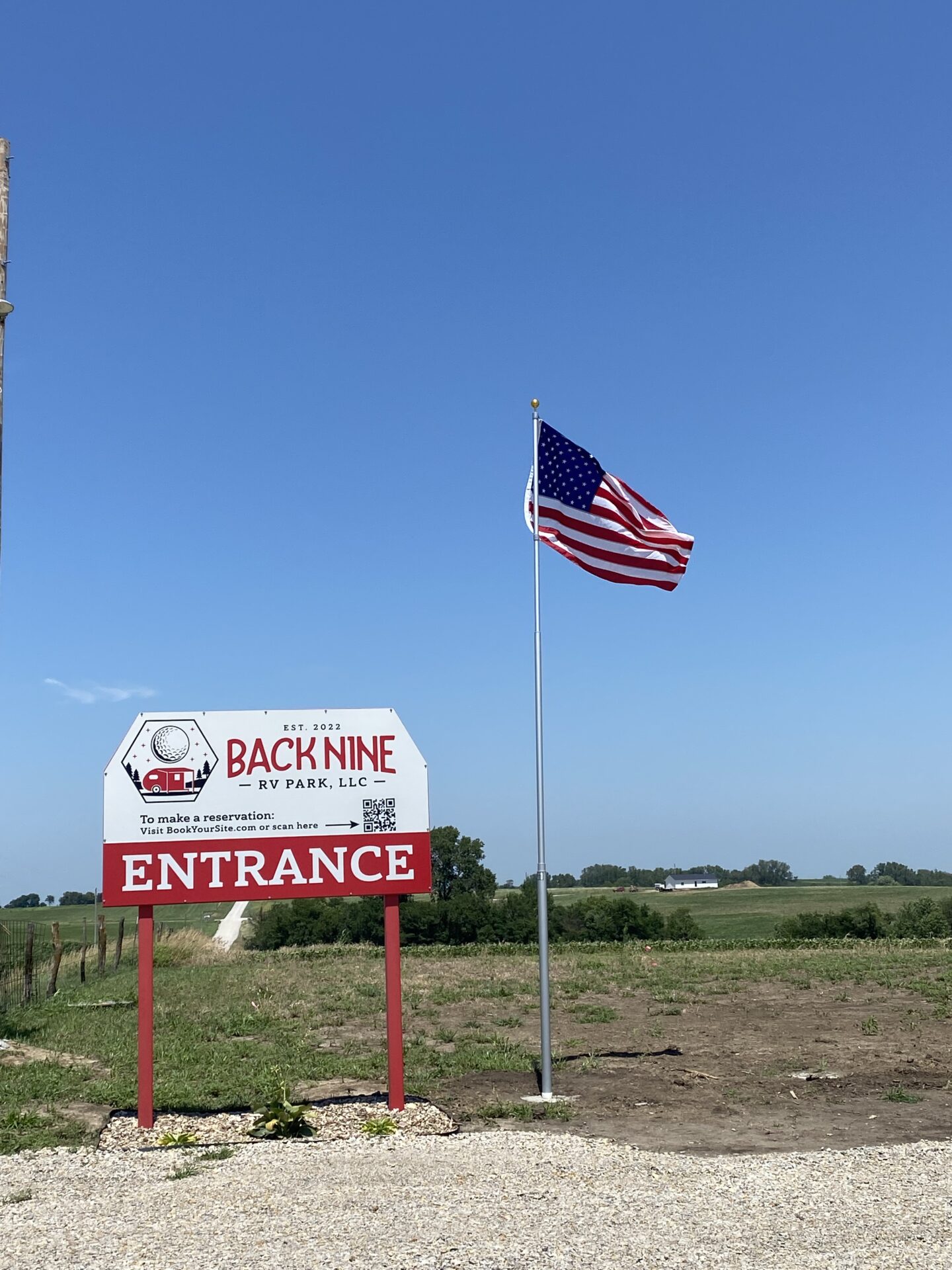 Entrance sign Back Nine RV Park Board and flag